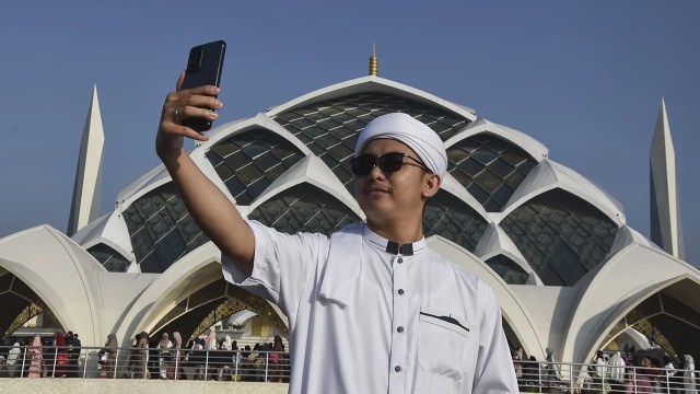A man takes a selfie at the Al Jabbar Grand Mosque in Bandung, West Java, Indonesia on April 22, 2023. (Dimas Rachmatsyah/INA Photo Agency/Universal Images Group via Getty Images)