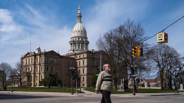 A man crosses the street in front of the state capital building in downtown Lansing, Michigan. (Spencer Platt/Getty Images)