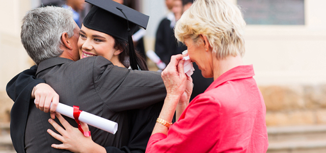 young female graduate hugging her father