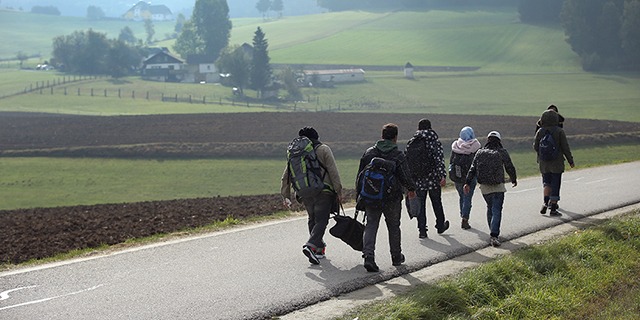 Migrants who had arrived via buses chartered by Austrian authorities walk toward the border to Germany on Oct. 17, 2015, near Fuchsoedt, Austria. (Sean Gallup/Getty Images)