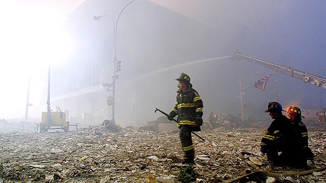 A firefighter walks through rubble of th