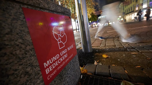 A sign in the old town area of Düsseldorf, Germany, calls on people to cover their nose and mouth. (Henning Kaiser/picture alliance via Getty Images)