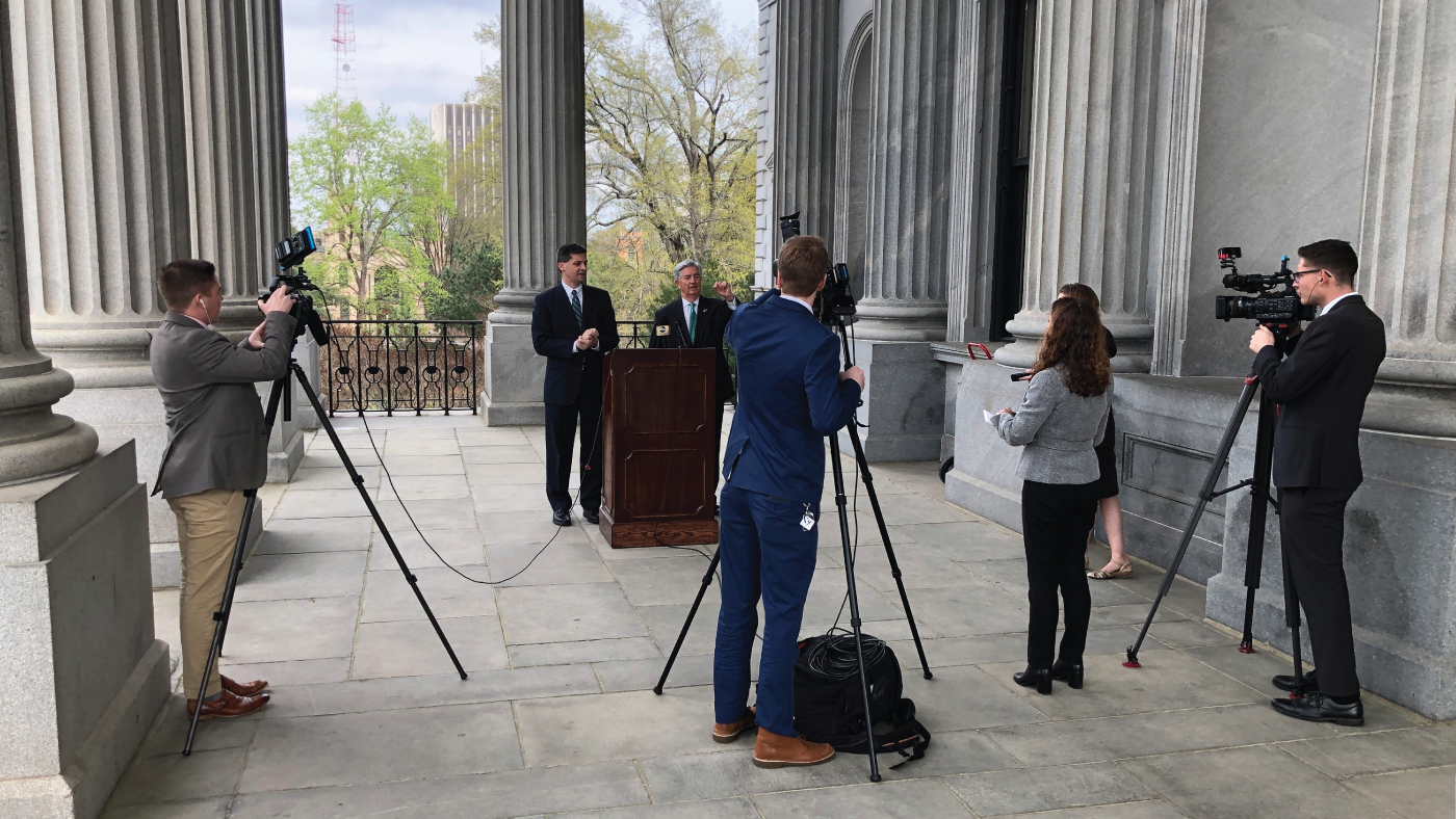 State Sens. Shane Massey, left, and Nikki Setzler speak to reporters outside the South Carolina State House in Columbia in March 2020. (Jeffrey Collins/AP)