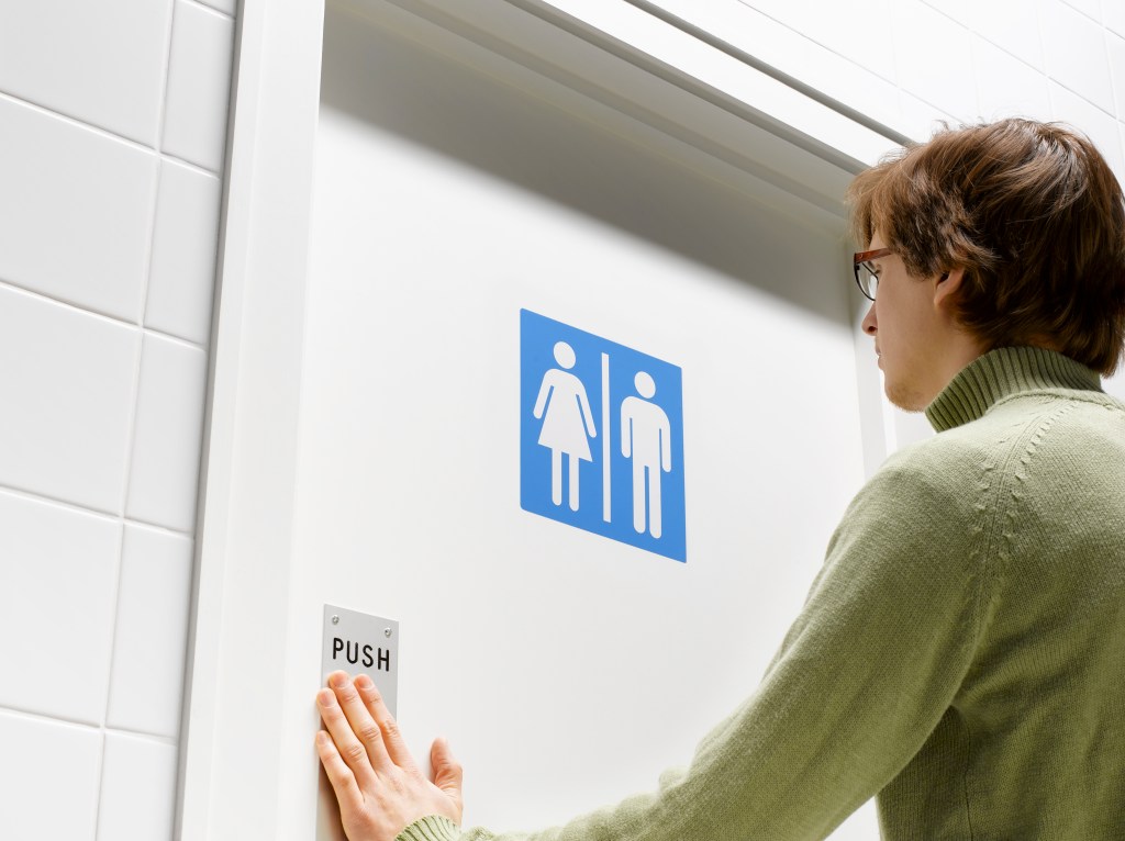 Man pushing toilet door