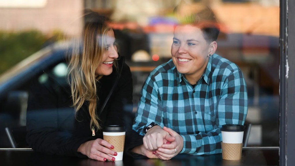 Two women sitting in a cafe enjoying each others company.