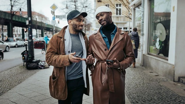 A gay couple walking down the street after meeting each other on a dating app, on their way to eat some food.
