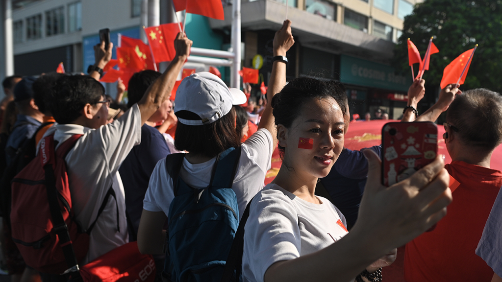 A woman takes a selfie during a pro-Beijing flash mob rally in Hong Kong on Oct. 1, 2019, to mark the 70th anniversary of communist China’s founding. (Philip Fong/AFP via Getty Images)