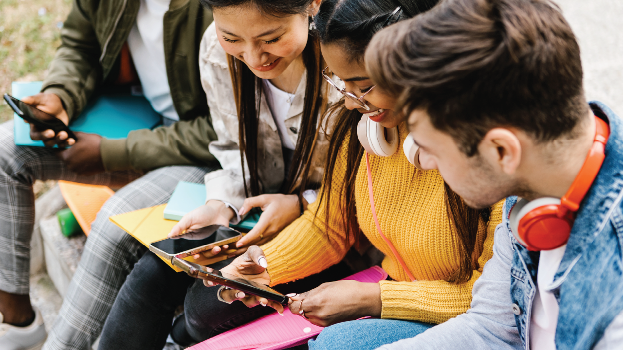 An image of teenagers using their smartphones together