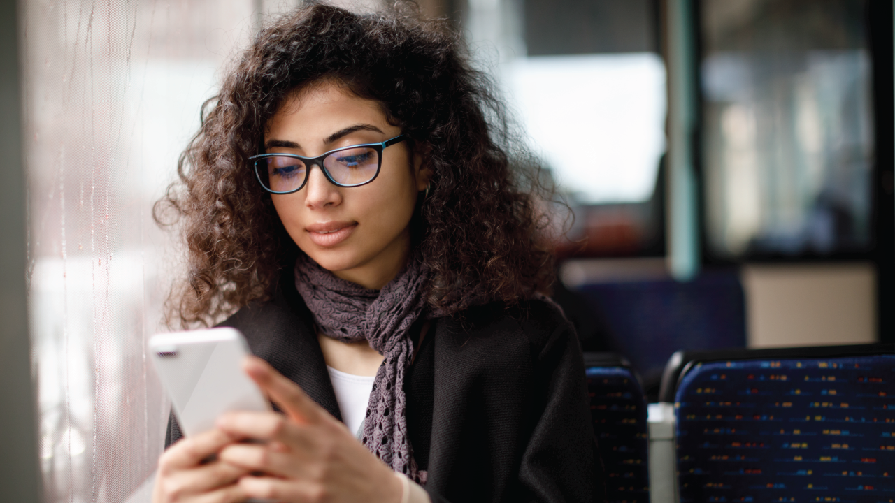 An image of a Hispanic woman looking at her smartphone.