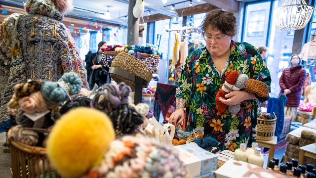 A small-business owner organizes display tables at her yarn shop in Boston. (Erin Clark/The Boston Globe via Getty Images)