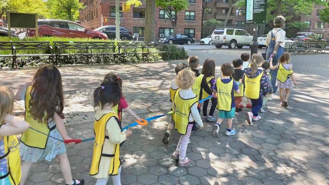 Children from Bright Horizons day care in New York City hold on to a cord to ensure they stay together while walking through a park. (Deb Cohn-Orbach/UCG/Universal Images Group via Getty Images)