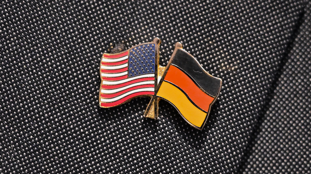 Two small flags as pins on a suit symbolize the German-American friendship.