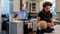 A mom prepares a snack for her son while her husband works remotely from a home office. (Raquel Natalicchio/Houston Chronicle via Getty Images)