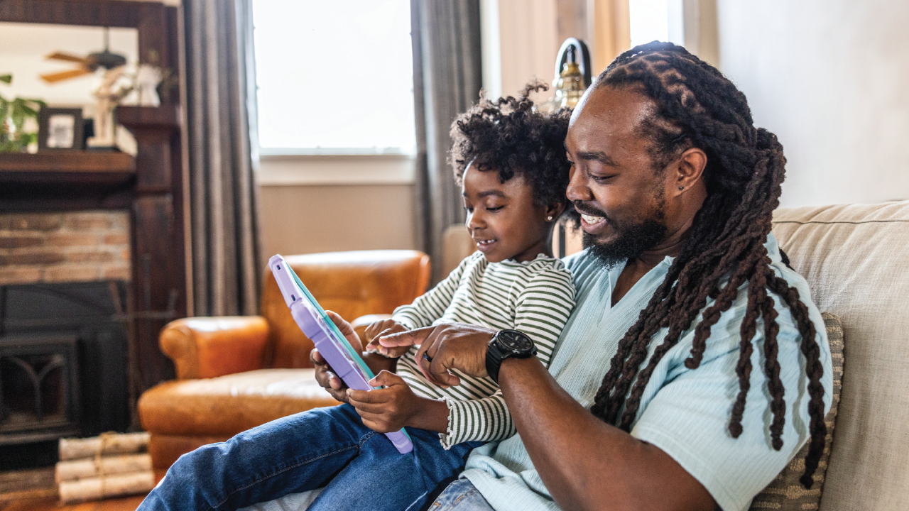 An image of a father and daughter using a tablet together