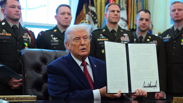 President Donald Trump poses with the 221st executive order he's signed in 2025. The executive order, issued on Dec. 15, classifies fentanyl as a "weapon of mass destruction." (Anna Moneymaker/Getty Images)