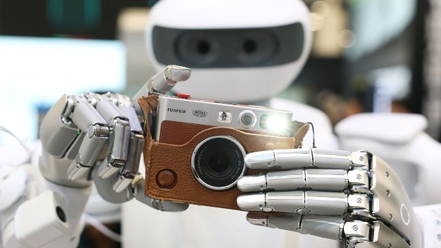 A full-body Sharpa robot takes a photograph with a Fujifilm camera during the 2026 Consumer Electronics Show in Las Vegas, Nevada, on Jan. 6. (Patrick Fallon/AFP via Getty Images)