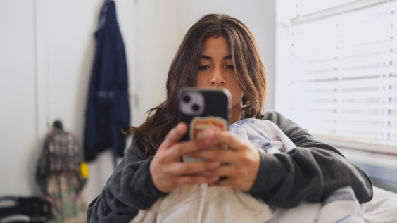 An image of a teen girl using a smartphone (Laura Olivas/Getty Images)