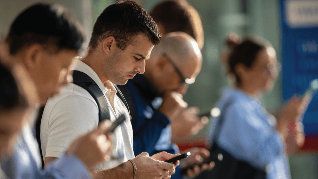 People check their phones at a train station in Stamford, Connecticut, on Aug. 28, 2023. (John Moore/Getty Images)