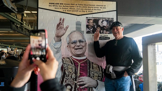 A baseball fan takes a photo with a mural of Pope Leo XIV before a White Sox game at Chicago's Rate Field on May 25, 2025. (Ben Hsu/Icon Sportswire via Getty Images)