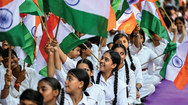 Students wave Indian flags in New Delhi on Aug. 12, 2025. (Money Sharma/AFP via Getty Images)