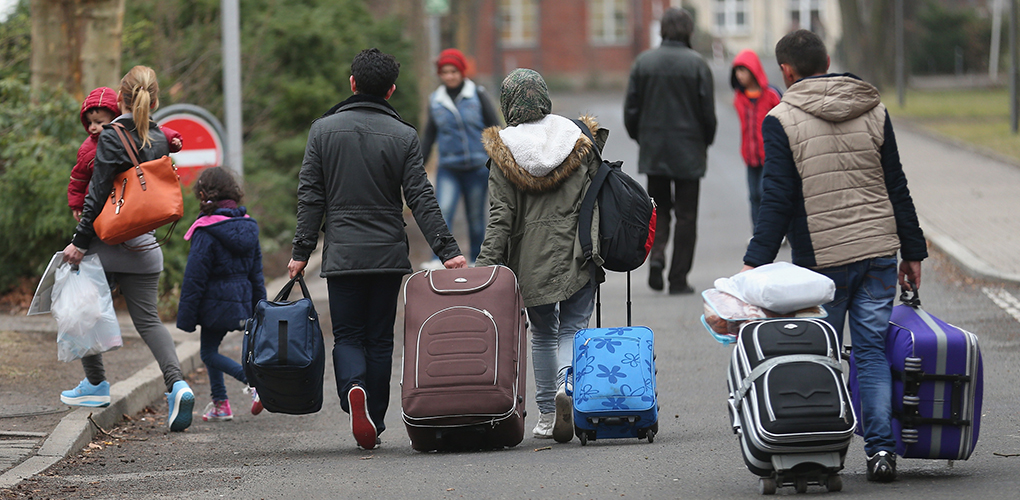 BERLIN, GERMANY - MARCH 11: People pulling suitcases arrive at the Central Registration Office for Asylum Seekers (Zentrale Aufnahmestelle fuer Fluechtlinge, or ZAA) of the State Office for Health and Social Services (Landesamt fuer Gesundheit und Soziales, or LAGeSo), which is the registration office for refugees and migrants arriving in Berlin who are seeking asylum in Germany, on March 11, 2015 in Berlin, Germany. Germany, which registered over 200,000 refugees in 2014, is expecting even more in 2015 and many cities and towns are reeling under the burden of having to accommodate them. The main countries of origin of the refugees include Syria, Serbia, Eritrea, Afghanistan, Iraq, Kosovo and Albania. (Photo by Sean Gallup/Getty Images)