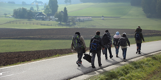 FUCHSOEDT, AUSTRIA - OCTOBER 17: Migrants who had arrived via buses chartered by Austrian authorities walk towards the border to Germany on October 17, 2015 near Fuchsoedt, Austria. According to a German police spokesman approximately 6,000 migrants are arriving daily over the Austrian border just in the area of southeastern Bavaria near the city of Passau. Most arrive via the Balkan route and once in Austria are transported by Austrian authorities to locations near the border to Germany. Germany has reportedly registered over 800,000 migrants this year, 400,000 in September alone. The migrants include many refugees from countries including Syria, Afghanistan and Iraq. Germany is struggling to accommodate the many migrants, most of whom will apply for asylum. (Photo by Sean Gallup/Getty Images)